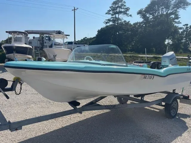 Slide: The Image of 1959 Glastron 15' Surflite boat on trailer, light blue and white, parked outdoors. - 4