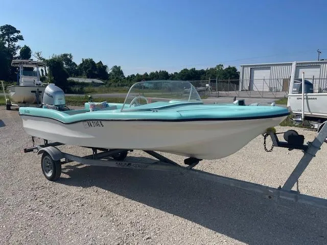 Slide: The Image of 1959 Glastron 15' Surflite boat on trailer, light blue and white, parked outdoors. - 1