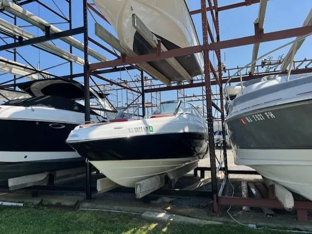 Slide: The Image of 2008 Yamaha Boats SX230 HO stored on a rack with other boats. - 5