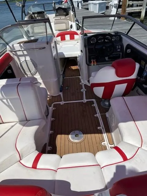 Slide: The Image of 2008 Yamaha Boats SX230 HO interior with red and white seating, wooden flooring, and dashboard controls. - 6