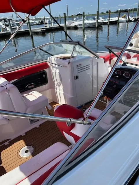 Slide: The Image of 2008 Yamaha Boats SX230 HO interior with red and white seating, docked at marina. - 7