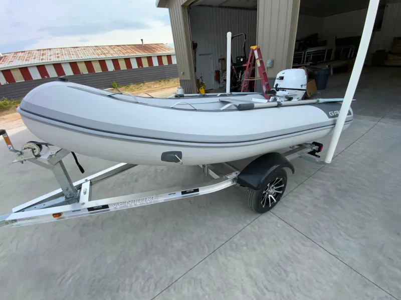 Slide: The Image of 2026 Gala A300 inflatable boat on trailer, parked outside a garage. - 8