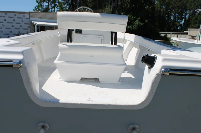 Slide: The Image of 2025 C-Hawk 19CC boat interior with white seating and console, surrounded by trees. - 12