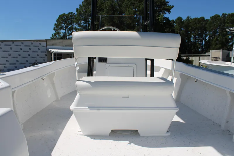 Slide: The Image of 2025 C-Hawk 19CC boat interior with white seating and console, surrounded by trees. - 14