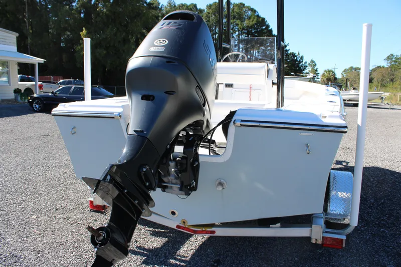 Slide: The Image of 2025 C-Hawk 19CC boat with powerful outboard motor, parked on gravel lot. - 2