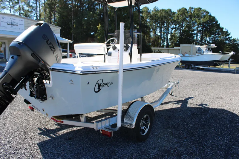 Slide: The Image of 2025 C-Hawk 19CC boat on trailer with Suzuki outboard motor in a marina setting. - 27
