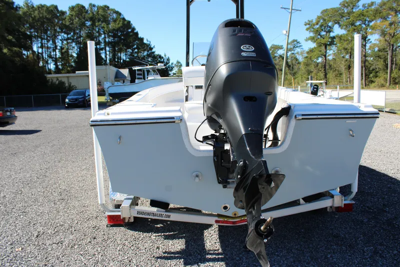Slide: The Image of 2025 C-Hawk 19CC boat with outboard motor on trailer, parked outdoors. - 4