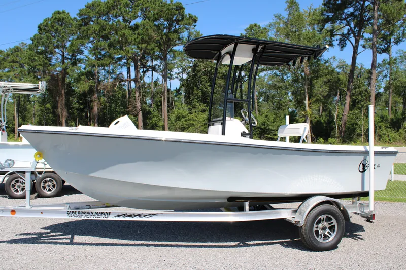 Slide: The Image of 2025 C-Hawk 19CC boat on trailer, parked outdoors with trees in background. - 6