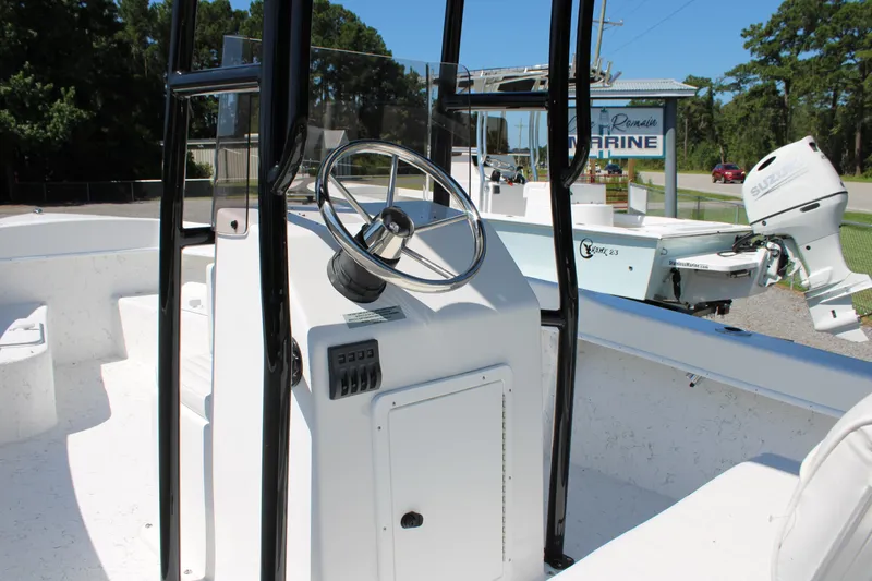 Slide: The Image of 2025 C-Hawk 19CC boat interior with steering console and Suzuki outboard motor. - 8