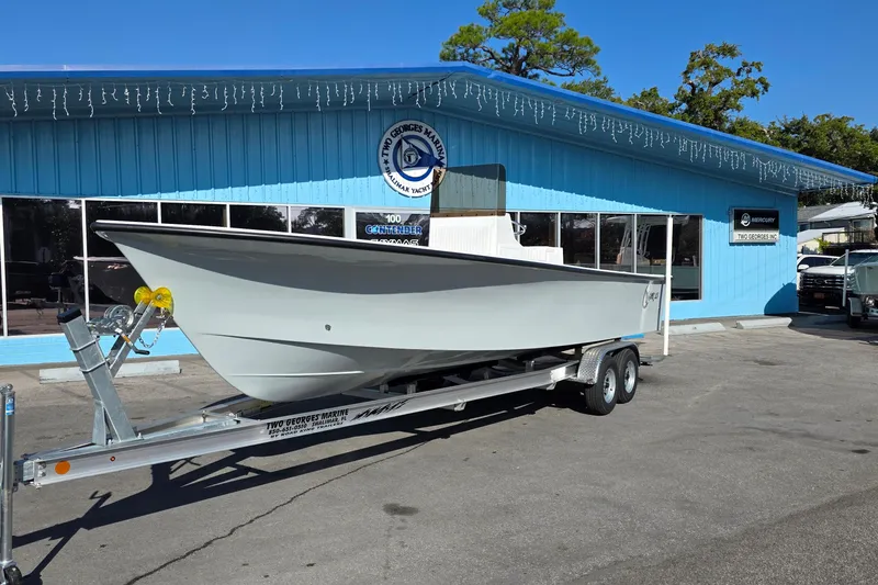 The Image of 2026 C-Hawk 25 boat on trailer outside a blue marine dealership. - 0