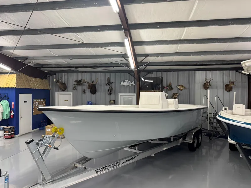 Slide: The Image of 2026 C-Hawk 25 boat displayed indoors on a trailer, surrounded by mounted animal heads. - 11