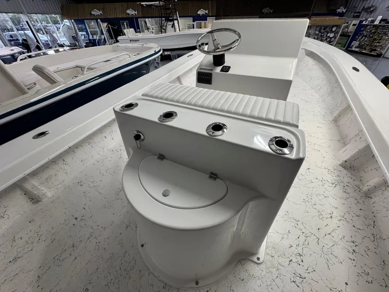 Slide: The Image of 2026 C-Hawk 25 boat interior with steering console and seating in showroom. - 13