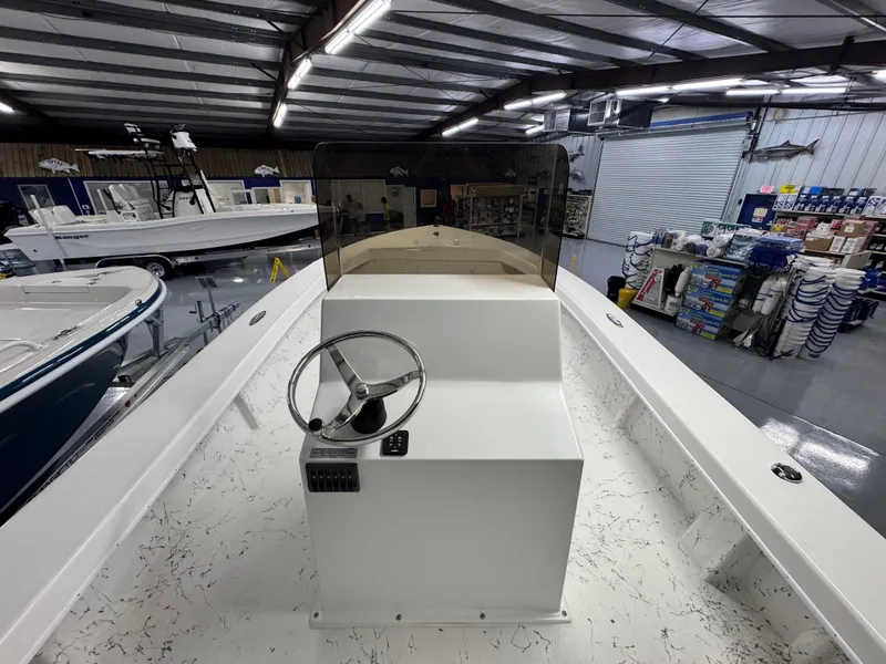 Slide: The Image of 2026 C-Hawk 25 boat interior with steering wheel, displayed in a showroom. - 15