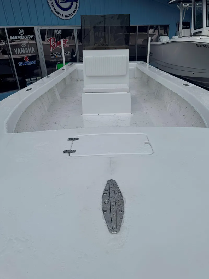 Slide: The Image of 2026 C-Hawk 25 boat interior with console and seating, displayed at a dealership. - 18