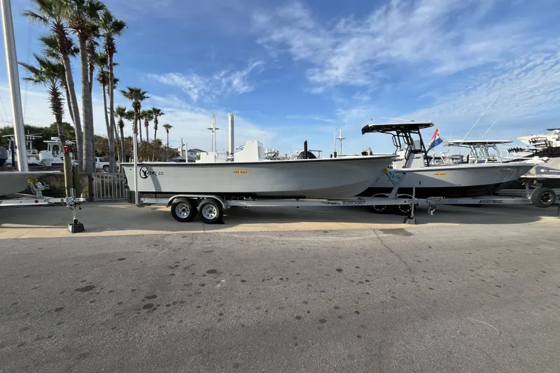 Slide: The Image of 2026 C-Hawk 25 boat on trailer, parked near palm trees, clear sky background. - 3