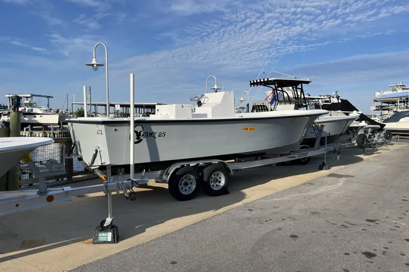 Slide: The Image of 2026 C-Hawk 25 boat on trailer, dockside, under clear sky. - 7
