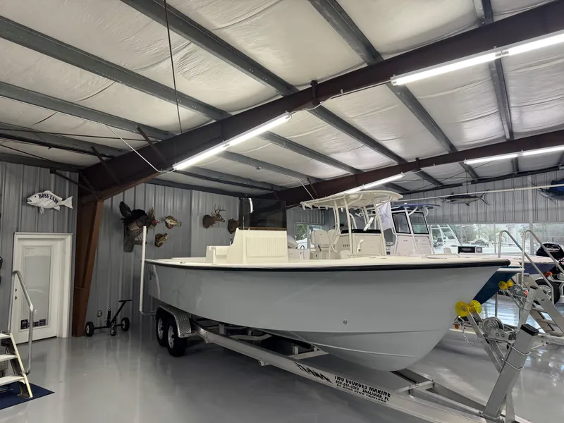 Slide: The Image of 2026 C-Hawk 25 boat displayed in a showroom with mounted fish decor. - 9