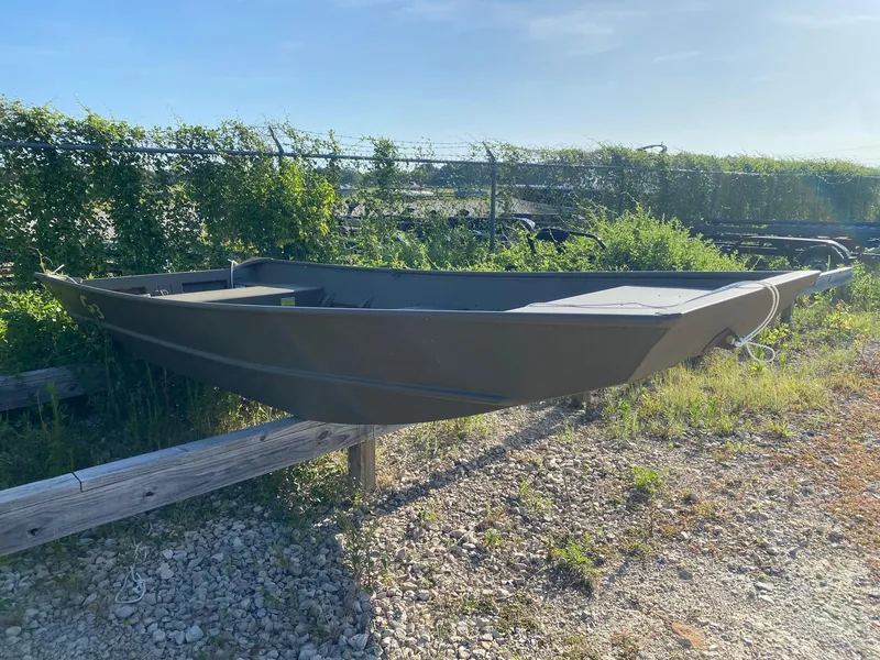 The Image of 2025 G3 Gator Tough 1442 boat on gravel, surrounded by greenery. - 0