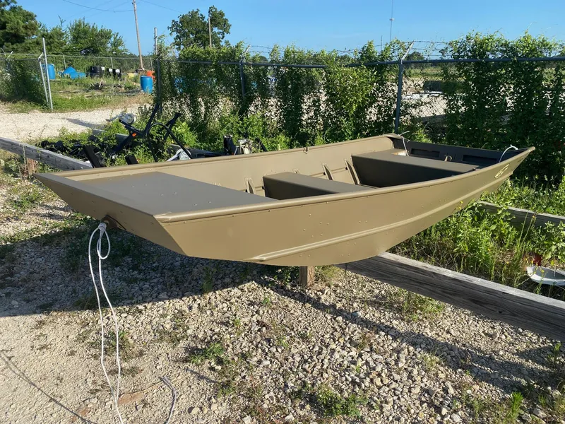 Slide: The Image of 2025 G3 Gator Tough 1442 boat on gravel, surrounded by greenery. - 2