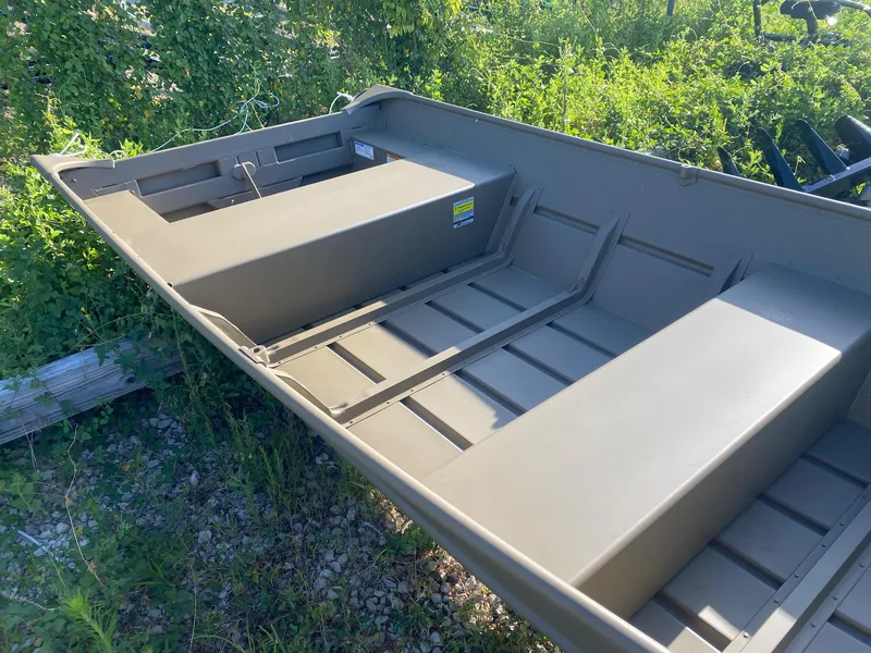 Slide: The Image of 2025 G3 Gator Tough 1442 boat interior, showing seating and storage, surrounded by greenery. - 5