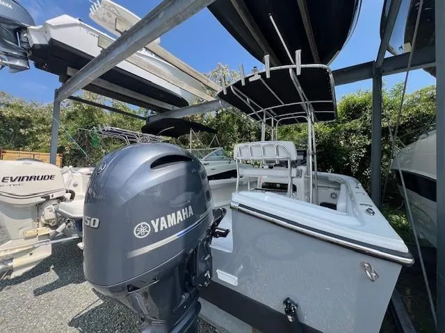 Slide: The Image of 2023 Parker 21SE Center Console boat with Yamaha engine, parked outdoors under a canopy. - 16