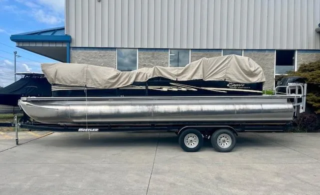 Slide: The Image of 2012 Bentley Pontoons 250/253 Party Cruise on trailer, covered, parked outside a building. - 6