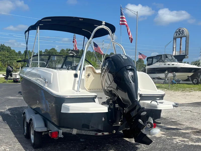 Slide: The Image of 2018 Bayliner Element F21 boat with Mercury outboard motor, parked on a trailer. - 14