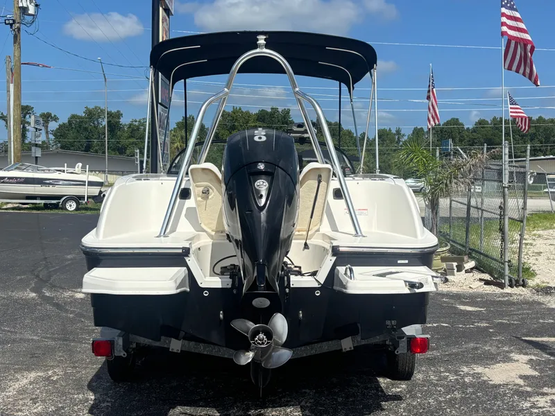 Slide: The Image of 2018 Bayliner Element F21 boat with outboard motor, parked outdoors under a clear blue sky. - 15