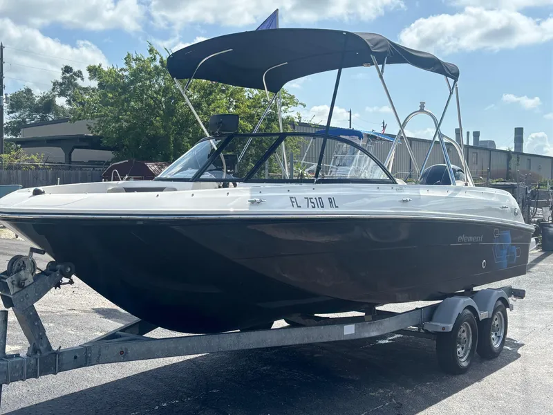 Slide: The Image of 2018 Bayliner Element F21 boat on trailer under sunny sky. - 20