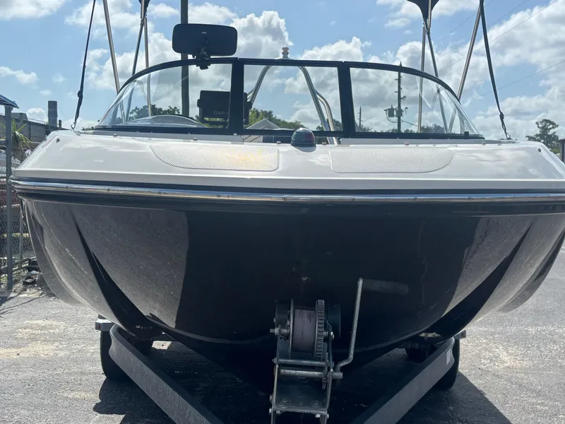 Slide: The Image of 2018 Bayliner Element F21 boat on trailer under a sunny sky. - 21