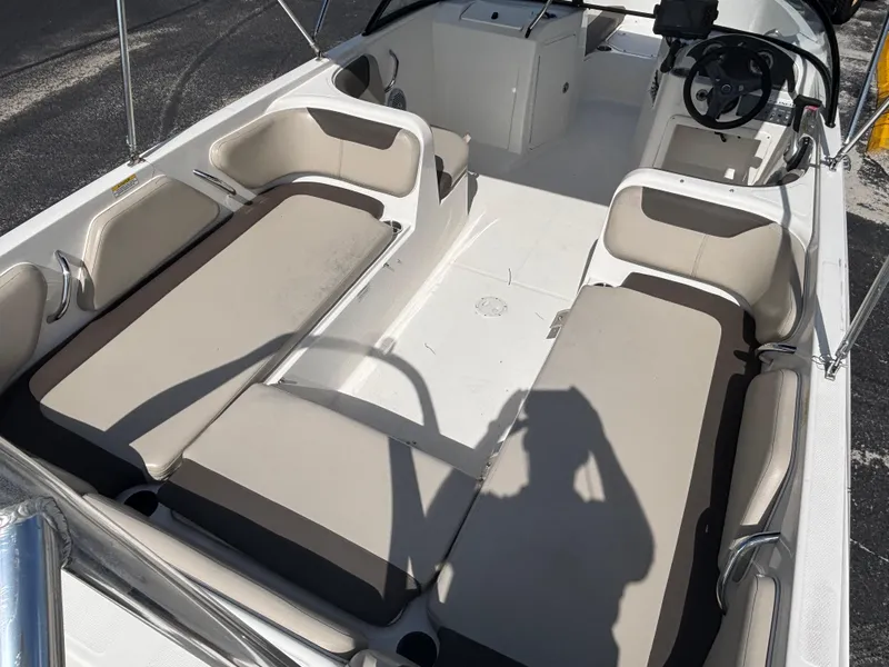 Slide: The Image of 2018 Bayliner Element F21 boat interior with beige seating and steering console. - 24