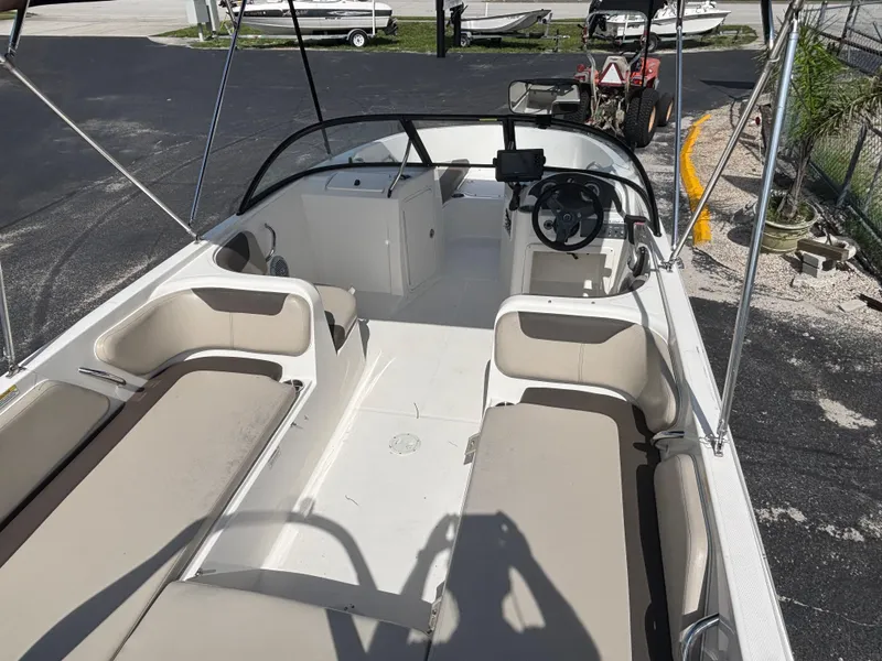 Slide: The Image of 2018 Bayliner Element F21 boat interior with seating and steering wheel. - 25