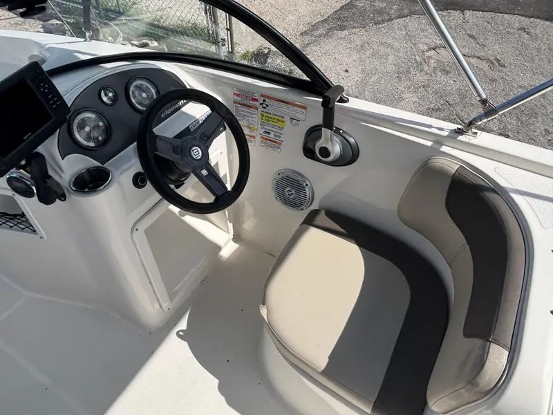 Slide: The Image of 2018 Bayliner Element F21 boat interior with steering wheel and seating area. - 26