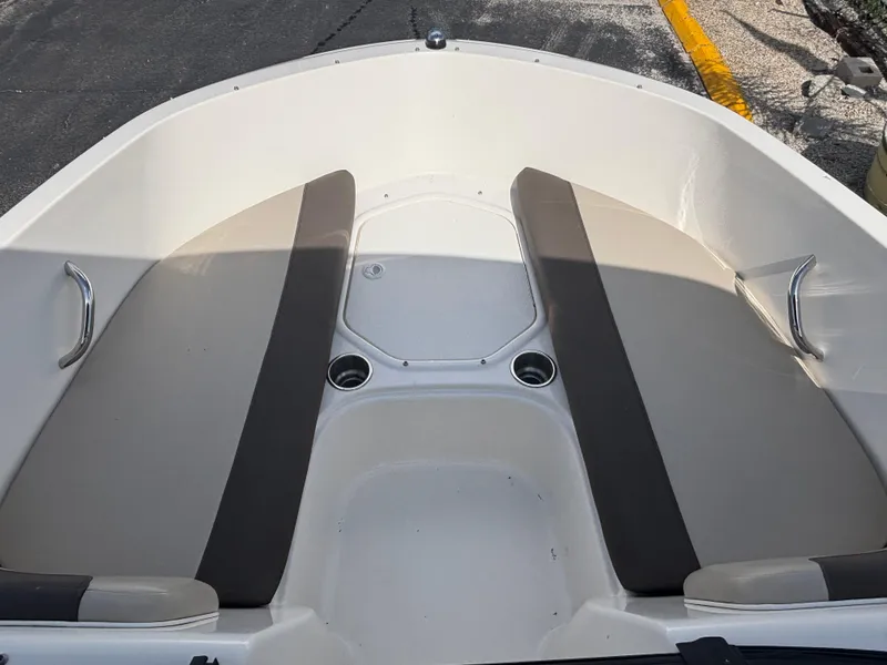 Slide: The Image of 2018 Bayliner Element F21 boat interior with cushioned seating and cup holders. - 28