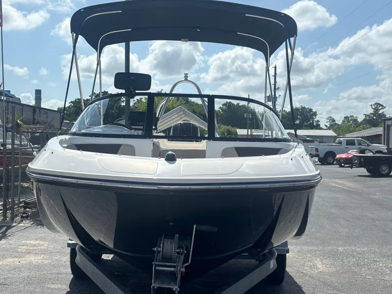 Slide: The Image of 2018 Bayliner Element F21 boat with canopy, parked on a trailer under a sunny sky. - 19
