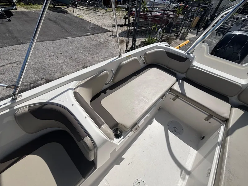 Slide: The Image of 2018 Bayliner Element F21 boat interior with cushioned seating and storage compartments. - 37