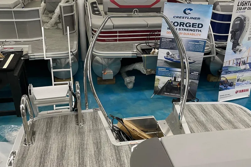 Slide: The Image of 2025 Bennington 23 SSB pontoon boat interior with stainless steel railings and promotional banners. - 3