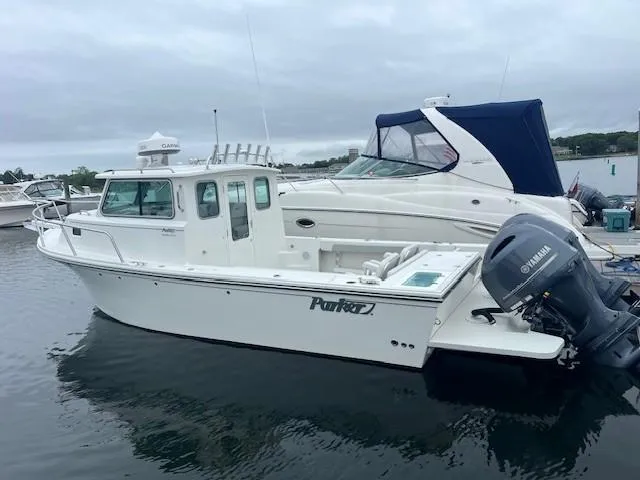 Slide: The Image of 2021 Parker 2520 XLD Sport Cabin boat docked with Yamaha outboard motor. - 12