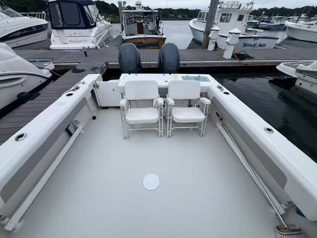 Slide: The Image of 2021 Parker 2520 XLD Sport Cabin boat docked, featuring spacious deck and twin engines. - 13