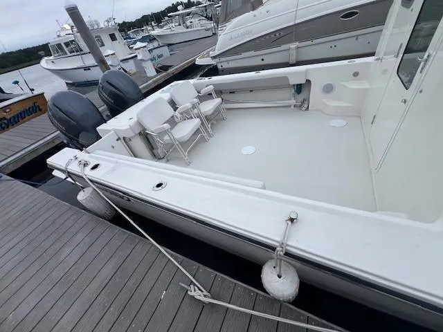 Slide: The Image of 2021 Parker 2520 XLD Sport Cabin boat docked with twin engines and spacious deck. - 17