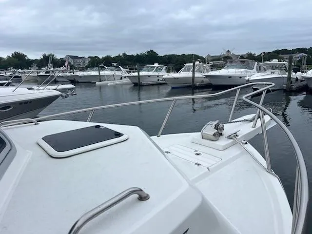 Slide: The Image of Parker 2520 XLD Sport Cabin 2021 in marina, surrounded by other boats on a cloudy day. - 19