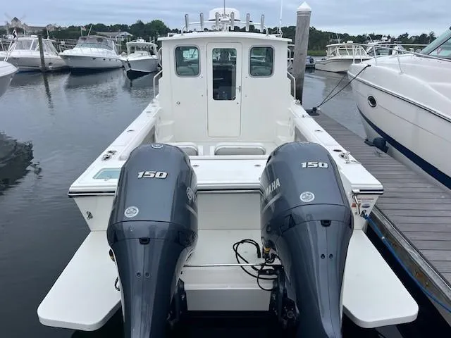 Slide: The Image of 2021 Parker 2520 XLD Sport Cabin boat with twin Yamaha 150 engines docked at marina. - 21
