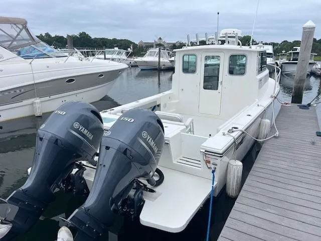 Slide: The Image of 2021 Parker 2520 XLD Sport Cabin boat docked with twin Yamaha 150 engines. - 22