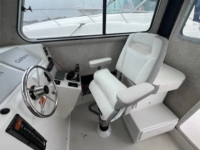 Slide: The Image of Interior of 2021 Parker 2520 XLD Sport Cabin with steering wheel and captain's chair. - 25