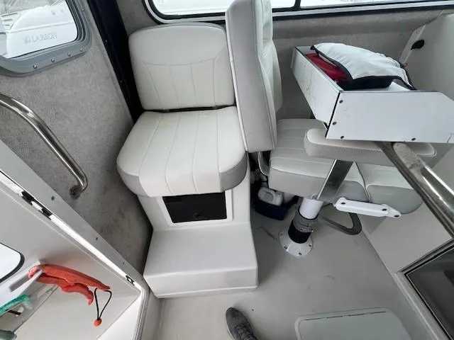 Slide: The Image of Interior of 2021 Parker 2520 XLD Sport Cabin with white seating and storage. - 30
