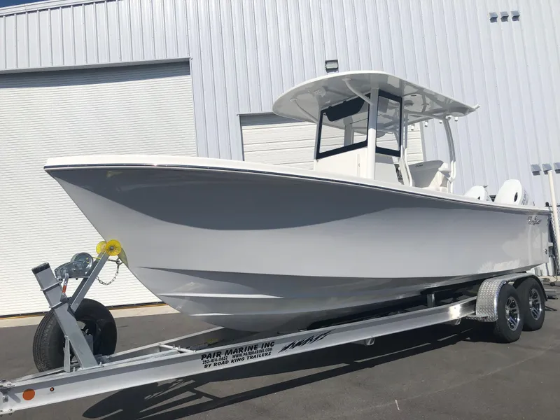 Slide: The Image of 2026 Pair Customs 24 Center Console DV boat on trailer, parked outside a warehouse. - 17