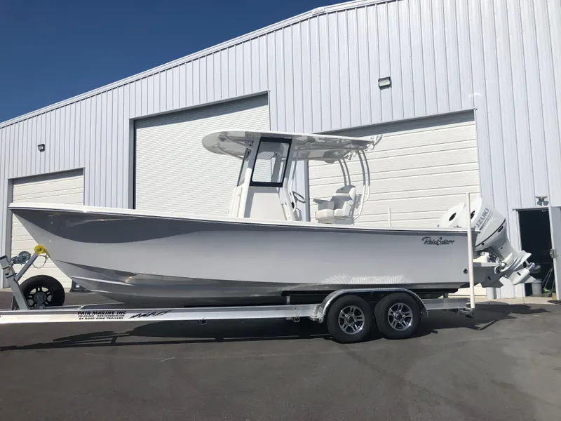 Slide: The Image of 2026 Pair Customs 24 Center Console DV boat on trailer outside a warehouse. - 18