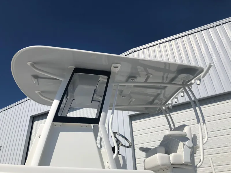 Slide: The Image of 2026 Pair Customs 24 Center Console DV boat with T-top and seating, against a clear sky. - 19