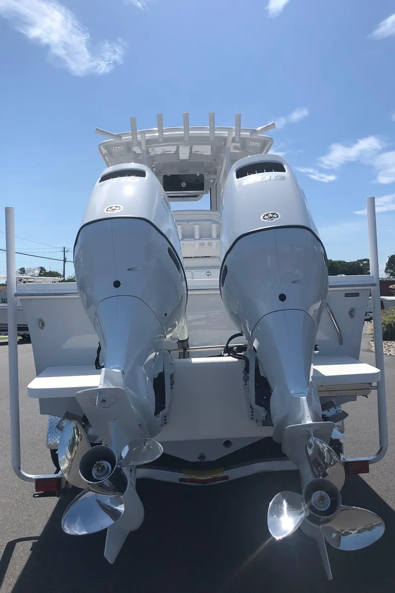 Slide: The Image of 2026 Pair Customs 24 Center Console DV with dual outboard motors, rear view. - 20
