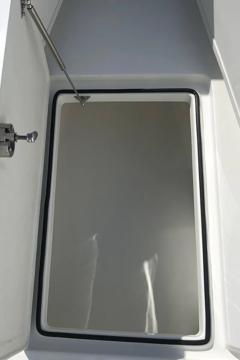 Slide: The Image of Open storage compartment on 2026 Pair Customs 24 Center Console DV boat. - 26